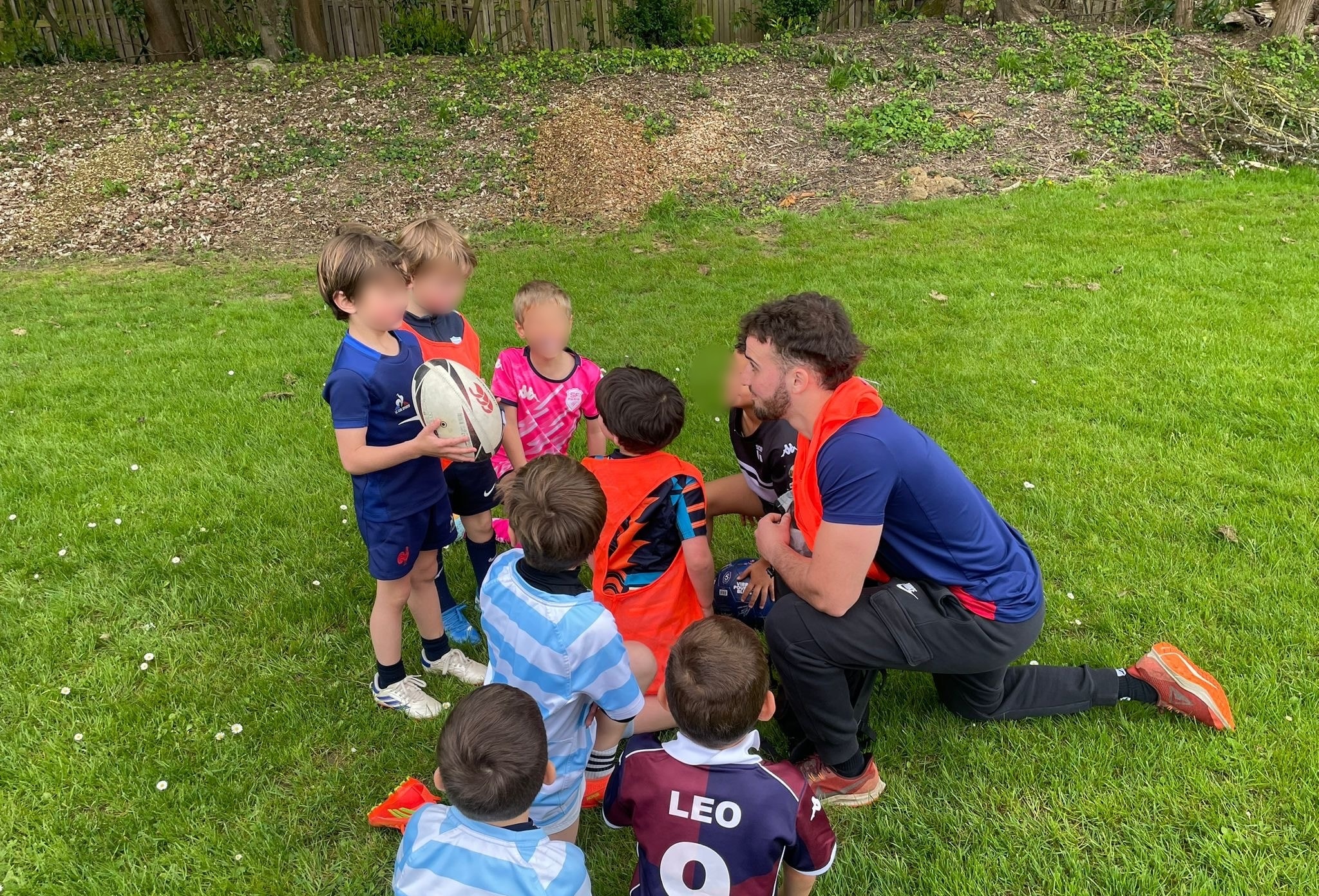 Coach avec bouclier de plaquage entouré d'enfants